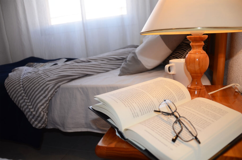 Book and reading glasses by bed