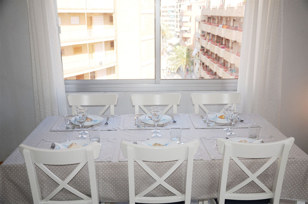 Dinner table for six people, all set with glasses and plates.