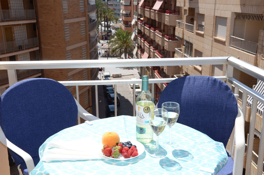 Wine and berries on a table on the balcony.