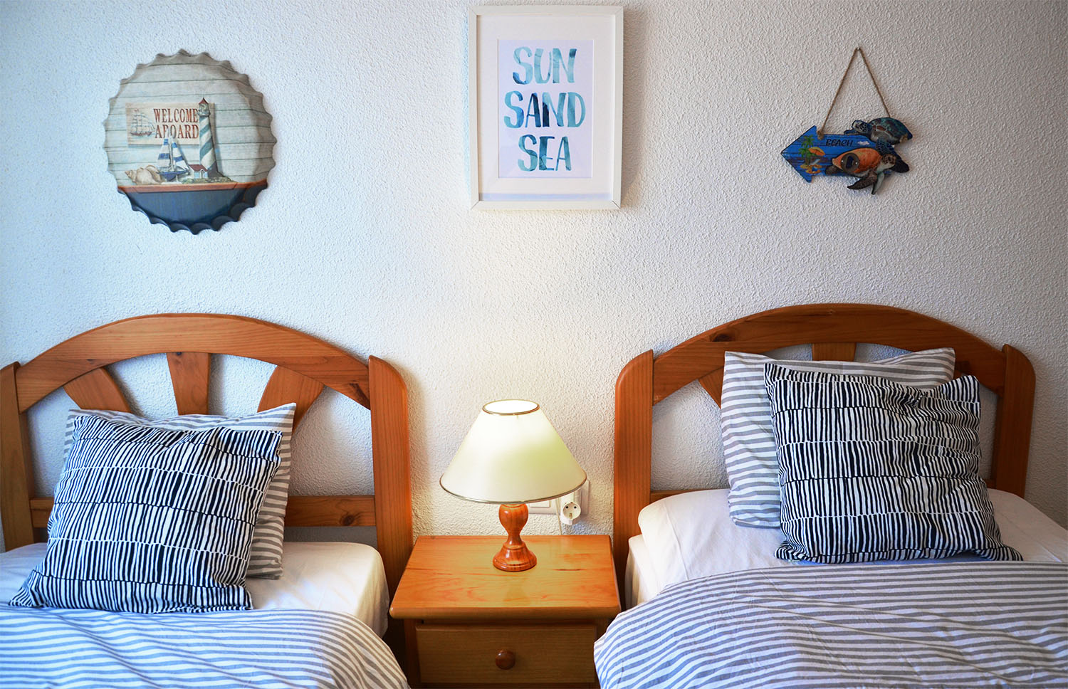 Two single beds and a lamp on a bed table.