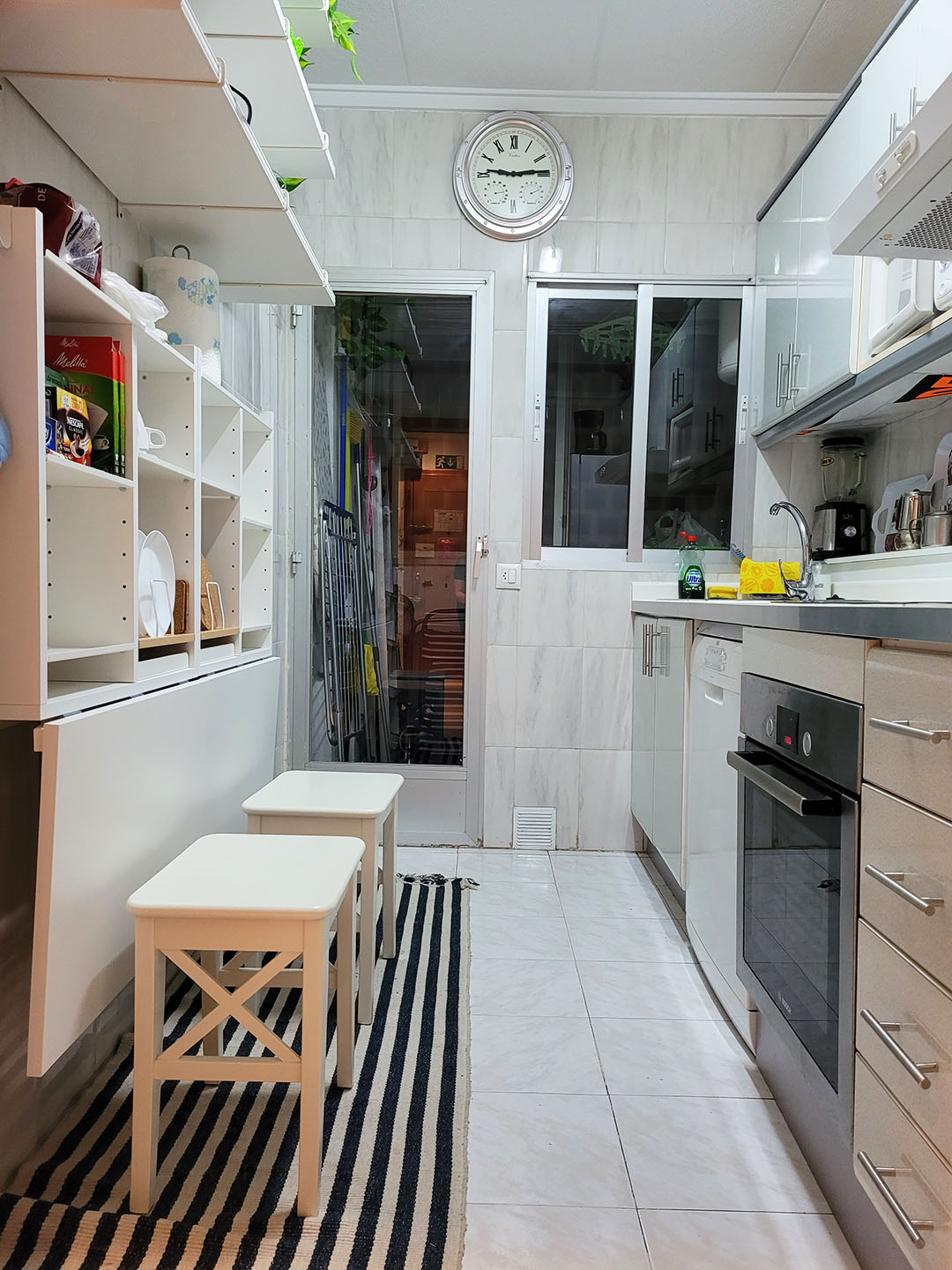 Kitchen with oven, chairs, and shelving,